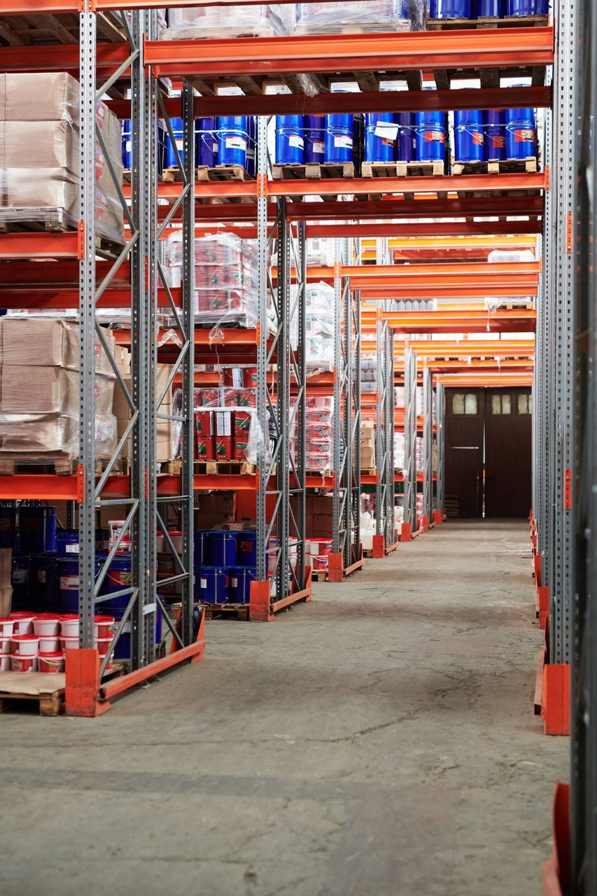 Free Industrial warehouse interior with organized shelves stacked with packages and goods. Stock Photo