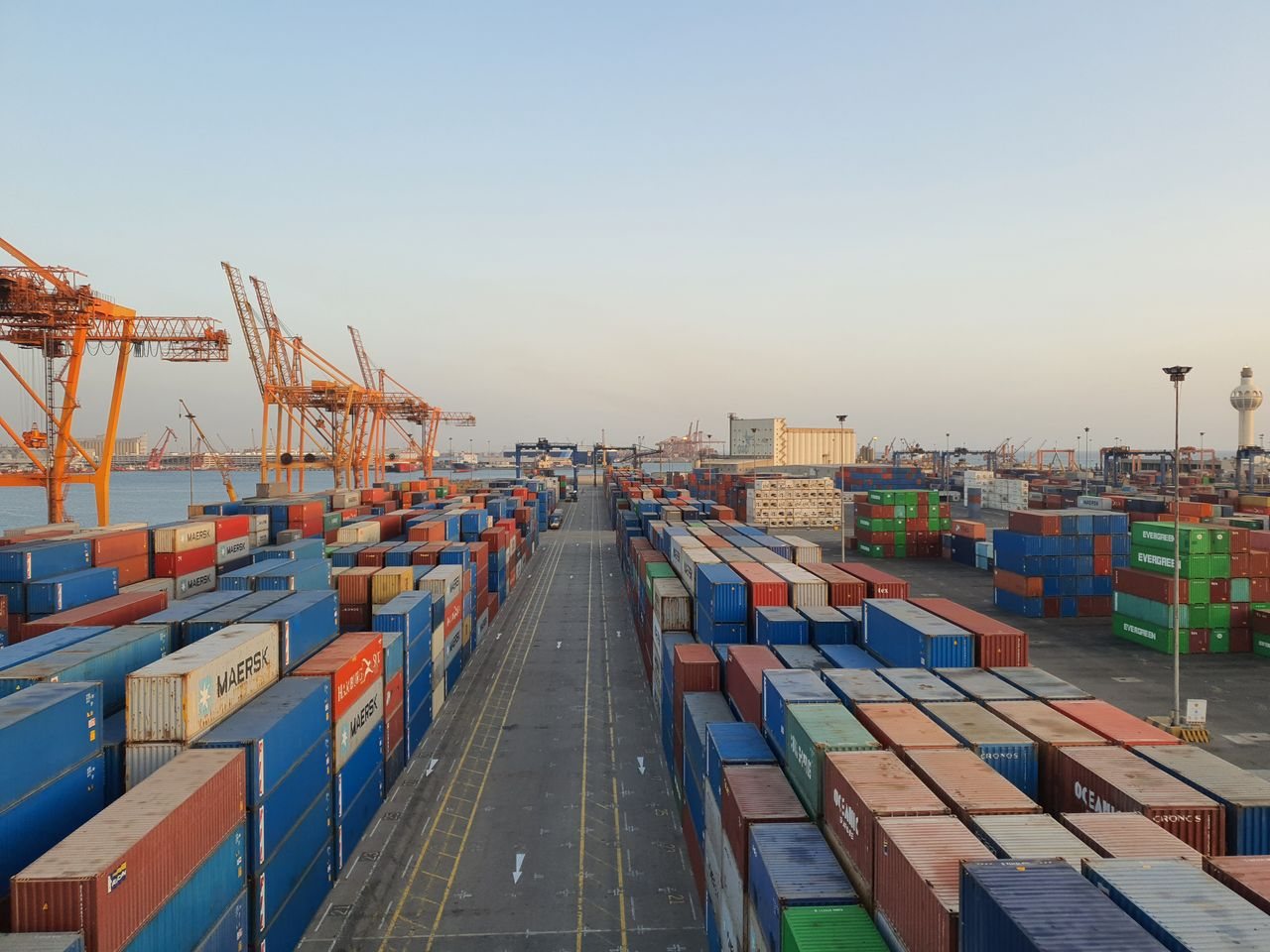 Free A bustling port scene with colorful cargo containers at sunrise. Ideal for logistics concepts. Stock Photo